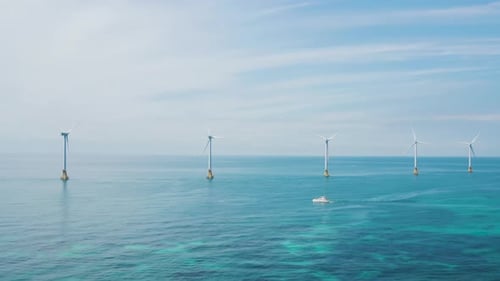 Beautiful scenery of wind turbines installed on the blue sea. Jeju island.