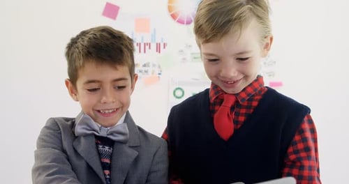 Two Boys Smile While Using Laptop