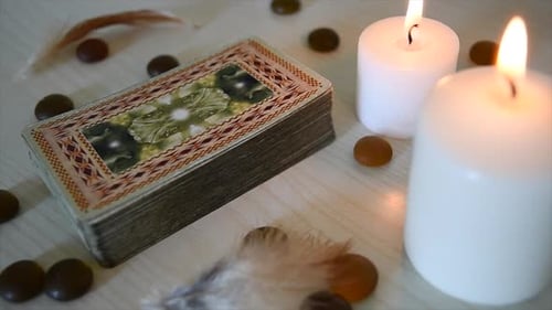 Zeitraffer eines Hintergrunds mit mystischen Karten Deck in der Nähe von Kerzen mit flackernden Flammen, Steinen und Fe
