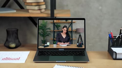 Laptop Standing on Table Display with Businesswoman in Office Writes in Notebook