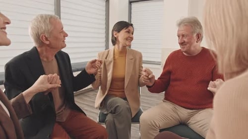 Adults in Circle Holding Hands and Talking