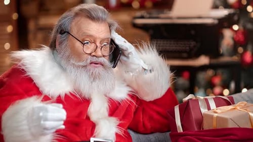 Man in Santa Claus Costume Having Conversation on Mobile