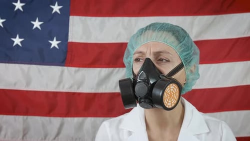 Woman Wearing Medical Mask and Cap in Front of Flag