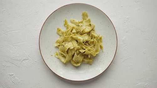 Clean View of Round Ceramic Plate with Tagliatelle Pesto Pasta