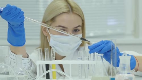 Woman in Lab Using Pipette to Transfer Liquid