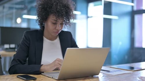 Serious African Businesswoman Working on Laptop in Office