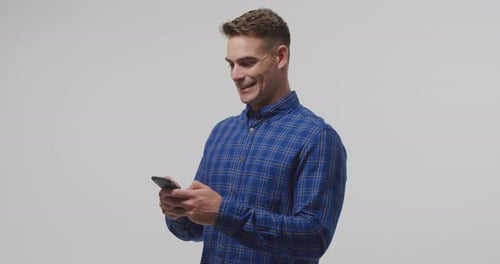 Smiling Young Adult Man Using Phone