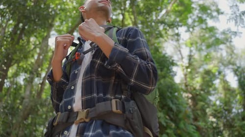 Asian young handsome male backpacker traveling alone in forest wild during holiday vacation trip.