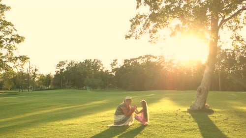 Grandmother and Granddaughter Talking in a Sunny Field