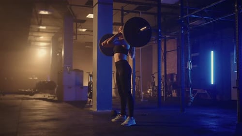 Athletic Beautiful Woman Does Overhead Deadlift with a Barbell in the Gym