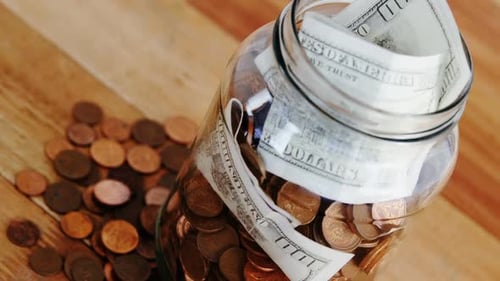 Close-up of coins and currency notes in bottle