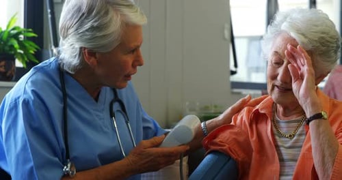 Senior Woman Gets Blood Pressure Taken by Caretaker