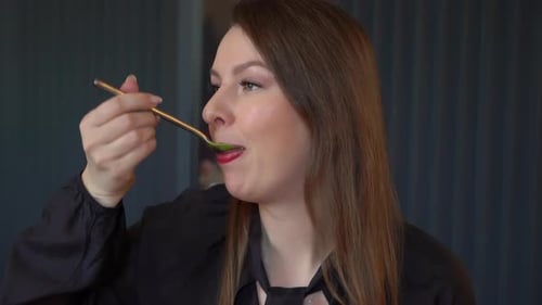 Woman Eating Green Soup in a Restaurant