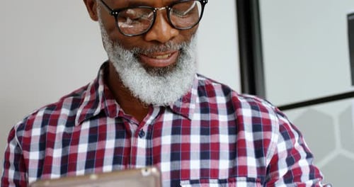Senior Male Executive Using Smartwatch While Working on Digital Tablet 4k