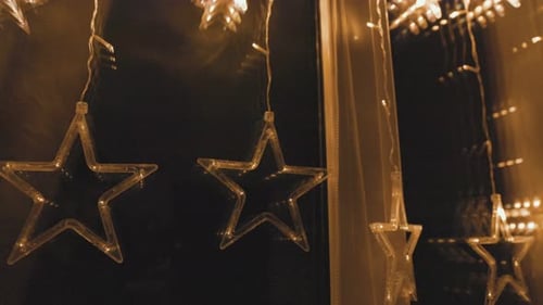 Sparkling Star Lights Hanging in Window at Night