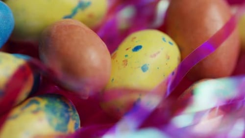 Rotierende Aufnahme von bunten Osterbonbons auf einem Bett aus Ostergras