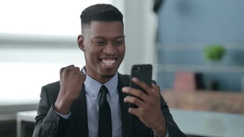 Excited Man Celebrates Good News on Smartphone