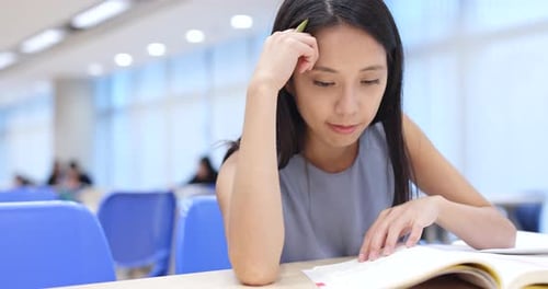 Junge Frau studiert an der Universitätsbibliothek