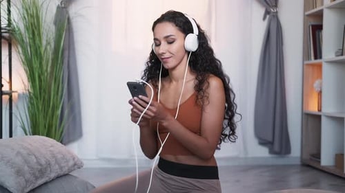 Woman Enjoys Music on Headphones At Home