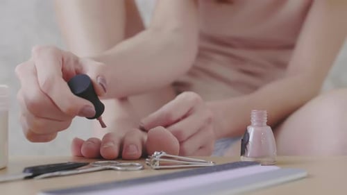 Young Woman Making Pedicure and Using Telephone