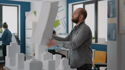 Man Architect analysiert Gebäudemodell und Maquette zur Planung von Stadteigentum