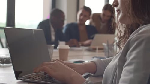 Jovem mestiça trabalhando no PC no escritório