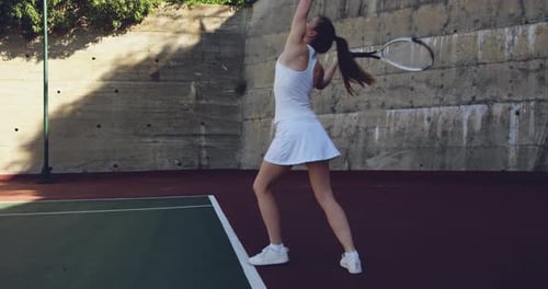 Young Woman Playing Tennis On Outdoor Court