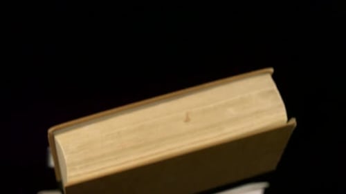 Old book falling on black background, Slow Motion