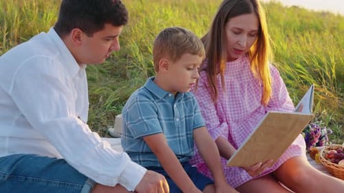 Family Reading Together in Sunny Field