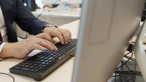 Man Typing at Computer in Modern Office