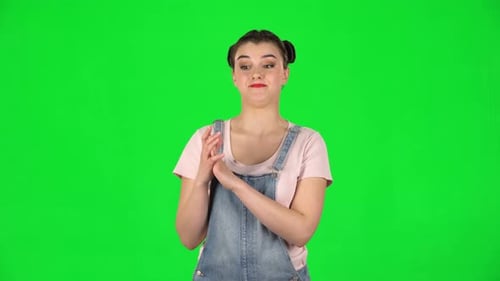 Girl with Two Hair-buns Claps Her Hands Indifferently on Green Screen