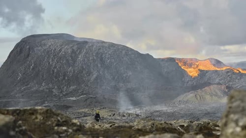 Man Walking In Landscape By Erupting Fagradalsfjall Volcano In Iceland