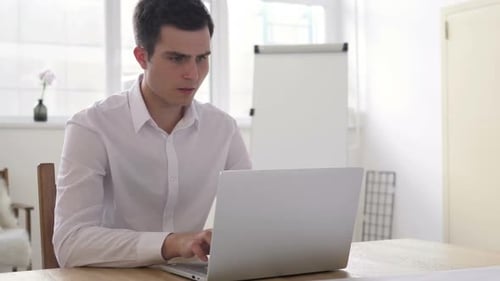 Man Working at Laptop in Bright Office