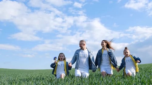 Joyful Family Running Through Lush Green Field