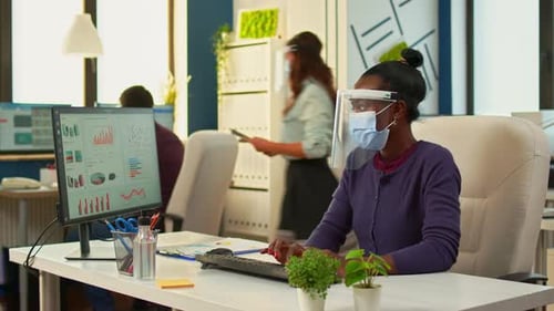 Femme noire travaillant sur ordinateur dans un nouveau bureau normal