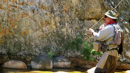 Fisherman fly fishing in river