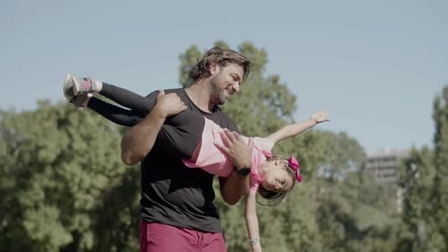 Father and Daughter Playing in Park on Sunny Day