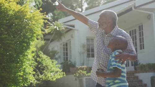 Grandfather Talking with Grandson in Sunny Yard