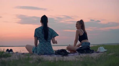 Young Women Enjoying Picnic at Sunset