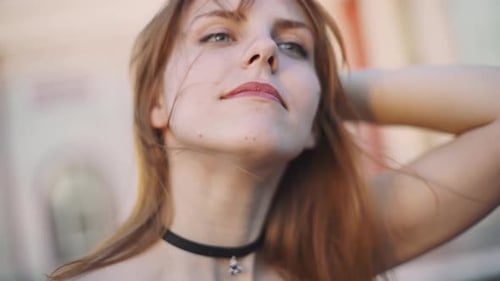 Woman Removes Helmet, Smiling with Hair Blowing