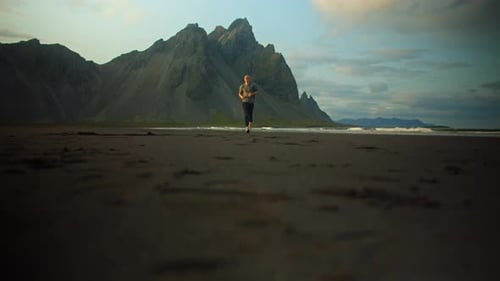 Man Running Through Open Volcanic Glacier Plain During Sunset With Beautiful Iceland