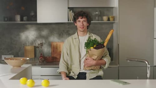 Positive Man Looking at Camera While Holding Grocery Bag