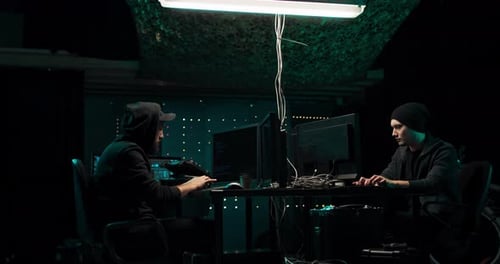 Men Working at Computers in a Dark Room