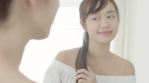 Young Woman Admiring Herself in the Mirror