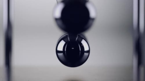 The balls of a Newtons Cradle colliding in slow motion