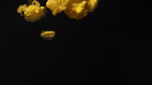 Luminous Yellow Ink Descending Against Black Background
