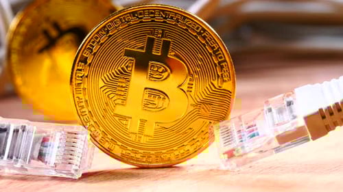 Close Up of Golden Bitcoin with Computer Cables