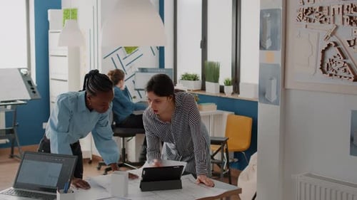 Team of Architects Working with Blueprints Plans and Tablet to Design Building Structure