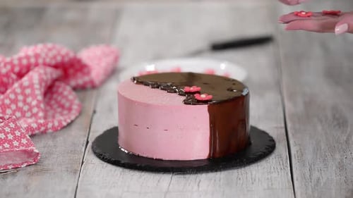 Baker Decorates a Pink Cake with Flowers