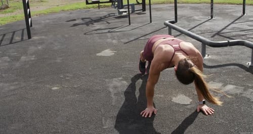 Sporty Caucasian woman exercising in an outdoor gym during daytime